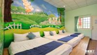 three beds in a room with a mural on the wall at Fumigate Hotel in Hengchun South Gate