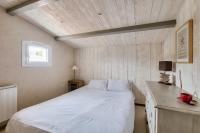 a bedroom with a white bed and a wooden ceiling at Havre de paix pour 10 a l Ile de Re in La Flotte
