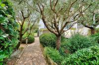 a path through a garden with trees and bushes at Havre de paix pour 10 a l Ile de Re in La Flotte