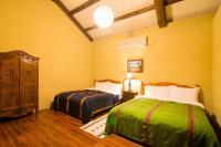 two beds in a room with yellow walls and wooden floors at Monet Garden Coffee Farm in Chinan
