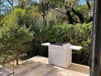 a white stove sitting on a patio next to some bushes at La Balouvière Villa entre Cévennes et Provence in Laudun