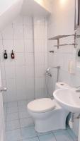 a white bathroom with a toilet and a sink at Sun B&amp;B in Taitung City