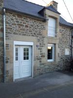 ein Steinhaus mit einer weißen Tür und einem Fenster in der Unterkunft Robert&#39;s Family Petite Maison de Ville in Plancoët