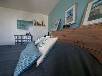 a bedroom with a bed with a wooden head board at Cap Marine - Petit cocon à Etel in Étel
