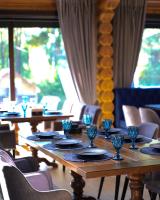 a long wooden table with plates and glasses on it at Hotel Golden Lion & SPA in Smyha