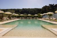 a swimming pool with chairs and umbrellas at Masseria Bandino &amp; Spa in Otranto