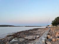 a boat is parked on the shore of a body of water at Diakofti house by the sea - Kythoikies hoilday houses in Kythira