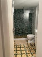 a bathroom with a shower and a toilet with a tile floor at Diakofti house by the sea - Kythoikies hoilday houses in Kythira