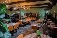 a restaurant with tables and chairs in a room at Villa de Beyaerd in Hulshorst