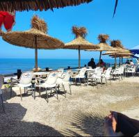 eine Gruppe von Stühlen und Sonnenschirmen an einem Strand in der Unterkunft Dar Sevilla in Asilah