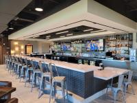 eine Bar mit einer Reihe von Tischen und Stühlen in der Unterkunft Homewood Suites by Hilton Tuscaloosa Downtown- Near Univ of Alabama in Tuscaloosa