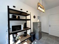 a kitchen with a shelf with a microwave and a refrigerator at Appartement Turquoise - 2 pers - Sedan in Sedan