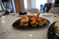 a plate with a sandwich and onion rings on a table at Doubletree Sulphur Lake Charles in Sulphur