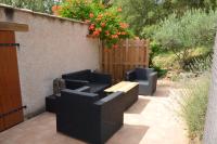 a patio with two chairs and a wooden table at Maison Amandre en Pleine Nature - Mas Lou Castanea in Collobrières