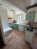 a kitchen with green cabinets and a tile floor at Maison Amandre en Pleine Nature - Mas Lou Castanea in Collobrières