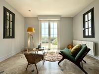 a living room with a green chair and a table at LUXURY ! Maison spacieuse de standing – Proche des plages in Ploemeur