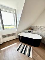 a large bath tub in a bathroom with a window at LUXURY ! Maison spacieuse de standing – Proche des plages in Ploemeur