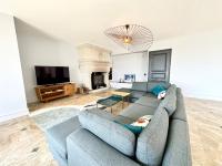 a living room with a blue couch and a tv at LUXURY ! Maison spacieuse de standing – Proche des plages in Ploemeur
