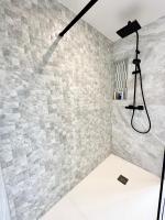 a shower in a bathroom with a stone wall at LUXURY ! Maison spacieuse de standing – Proche des plages in Ploemeur