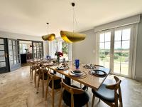 a dining room with a large wooden table and chairs at LUXURY ! Maison spacieuse de standing – Proche des plages in Ploemeur