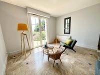 an empty living room with a chair and a table at LUXURY ! Maison spacieuse de standing – Proche des plages in Ploemeur