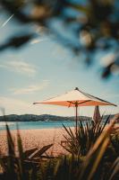 ein Sonnenschirm am Strand in der Nähe des Wassers in der Unterkunft Les Prairies de la Mer in Grimaud
