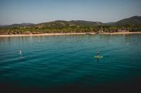 zwei Personen auf Paddleboards im Wasser in der Nähe eines Strandes in der Unterkunft Les Prairies de la Mer in Grimaud