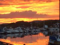 Un grupo de barcos atracados en un puerto deportivo al atardecer en Ny Leilighet i Nevlunghavn, en Larvik