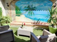 a mural of a beach with a table and chairs at superbe appartement de 50 m2 avec Jacuzzi in Fontaine