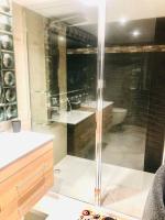 a glass shower in a bathroom with a sink at superbe appartement de 50 m2 avec Jacuzzi in Fontaine