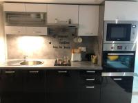 a kitchen with a sink and a microwave at superbe appartement de 50 m2 avec Jacuzzi in Fontaine