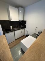 a small kitchen with white cabinets and a sink at Le Jacquard in Calais