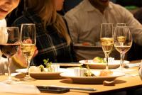 een groep mensen die aan een tafel zitten met wijnglazen bij Fenix Furano in Furano
