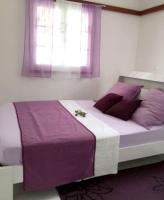 a bedroom with a large bed with purple pillows at Maison de 2 chambres avec vue sur la mer jardin amenage et wifi a Vieux Habitants a 2 km de la plage in Vieux-Habitants