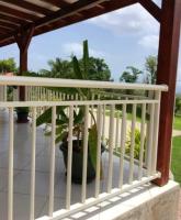 a porch with a white rail and a plant at Maison de 2 chambres avec vue sur la mer jardin amenage et wifi a Vieux Habitants a 2 km de la plage in Vieux-Habitants
