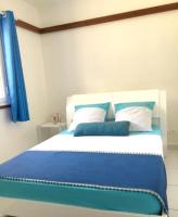 a bed with blue and white sheets and pillows at Maison de 2 chambres avec vue sur la mer jardin amenage et wifi a Vieux Habitants a 2 km de la plage in Vieux-Habitants