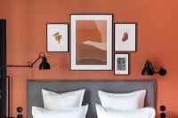 a bedroom with orange walls and a bed with white pillows at Deskopolitan House in Paris