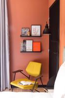 a yellow chair in a room with an orange wall at Deskopolitan House in Paris