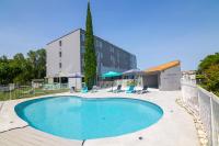 Una piscina con sillas y un edificio. en Kyriad Direct - Bourg les Valence, en Bourg-lès-Valence