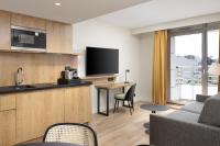 a kitchen and living room with a couch and a tv at Residence Inn by Marriott Paris Didot Montparnasse in Paris