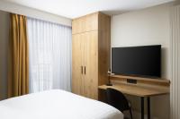 a bedroom with a bed and a desk with a television at Residence Inn by Marriott Paris Didot Montparnasse in Paris