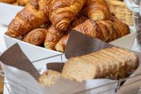 a box of croissants and breads on a table at Residence Inn by Marriott Paris Didot Montparnasse in Paris