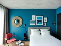 a blue bedroom with a bed and a red chair at Deskopolitan House in Paris
