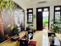 un vestíbulo con mesas y una gran pintura en la pared en Home Tea An Yên Dorm, en Ho Chi Minh