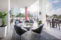 a patio with chairs and tables on a balcony at Marriott Fort Lauderdale Airport in Dania Beach