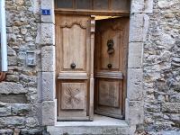 a pair of wooden doors in a stone building at La Jolie Dourbie de Nant in Nant