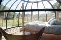 a bedroom with a bed in a glass house at Dihan Evasion in Ploemel