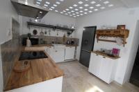 a kitchen with white cabinets and a black refrigerator at Gite sur la Founintrouze in Fabrezan