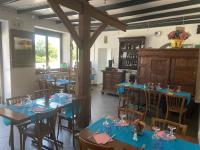 een restaurant met blauwe tafels en stoelen en een keuken bij Le Bouthiry in Le Saint