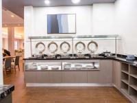 Una cocina con cuatro fregaderos y espejos en una encimera. en Krystal Urban Monterrey San Jeronimo, en Monterrey